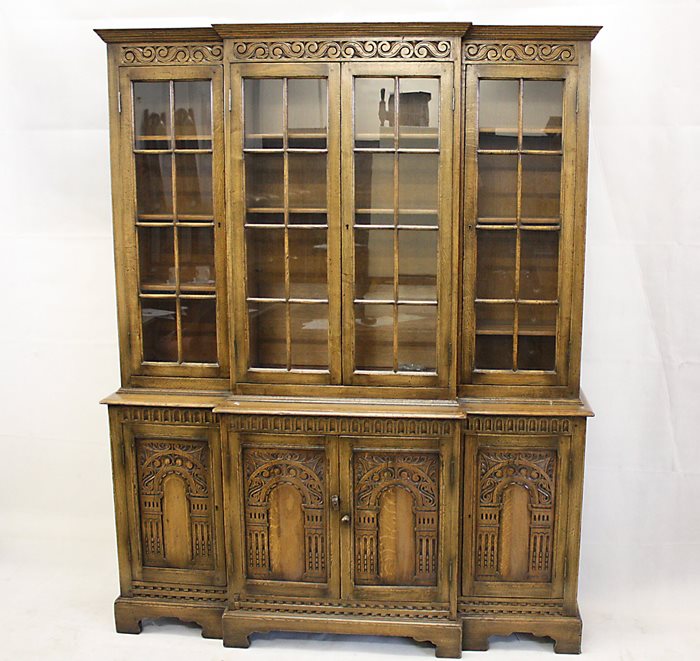 A reproduction oak elevated breakfront bookcase