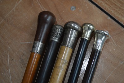 Lot 105 - Five silver and white metal topped and collared walking canes,`