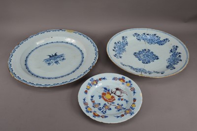 Lot 151 - Two damaged 19th century tin-glazed earthenware Delft chargers, both with blue and white decoration, staple repairs, the largest 38.5cm diameter, together with a smaller tin-glazed plate, with floral