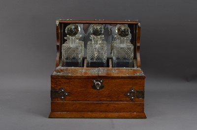 Lot 446 - A 20th century oak and metal mounted three decanter tantalus