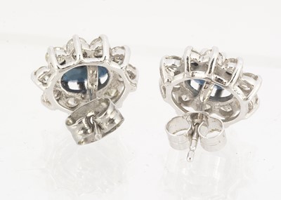 Lot 83 - A pair of oval sapphire and diamond cluster stud earrings