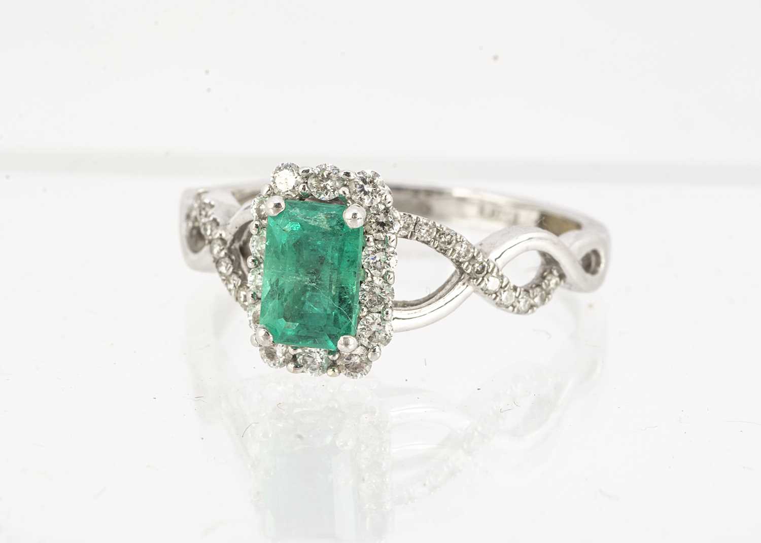 Lot 87 - An emerald and diamond cluster ring