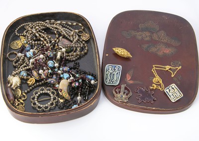 Lot 134 - A lacquer Japanese oval dressing table box with a collection of costume jewels