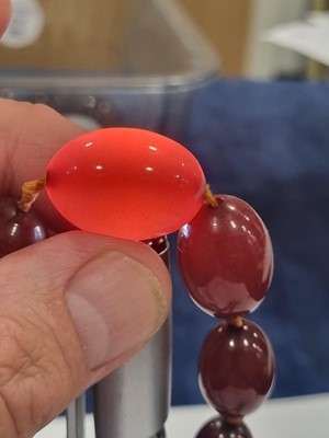 Lot 135 - A 'cherry amber' graduated knotted oval bead necklace