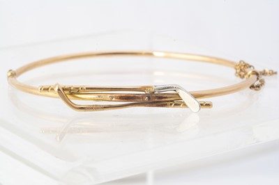 Lot 243 - A yellow metal hinged golfing bangle