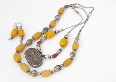 Lot 254 - A North African amber and white metal pendant and chain necklace