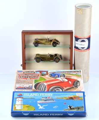 Lot 402 - Schyllling modern clockwork Island Ferry and Speedway Tin Toys Matchbox shop display shelf cover and Brass cars and two shelf Display case