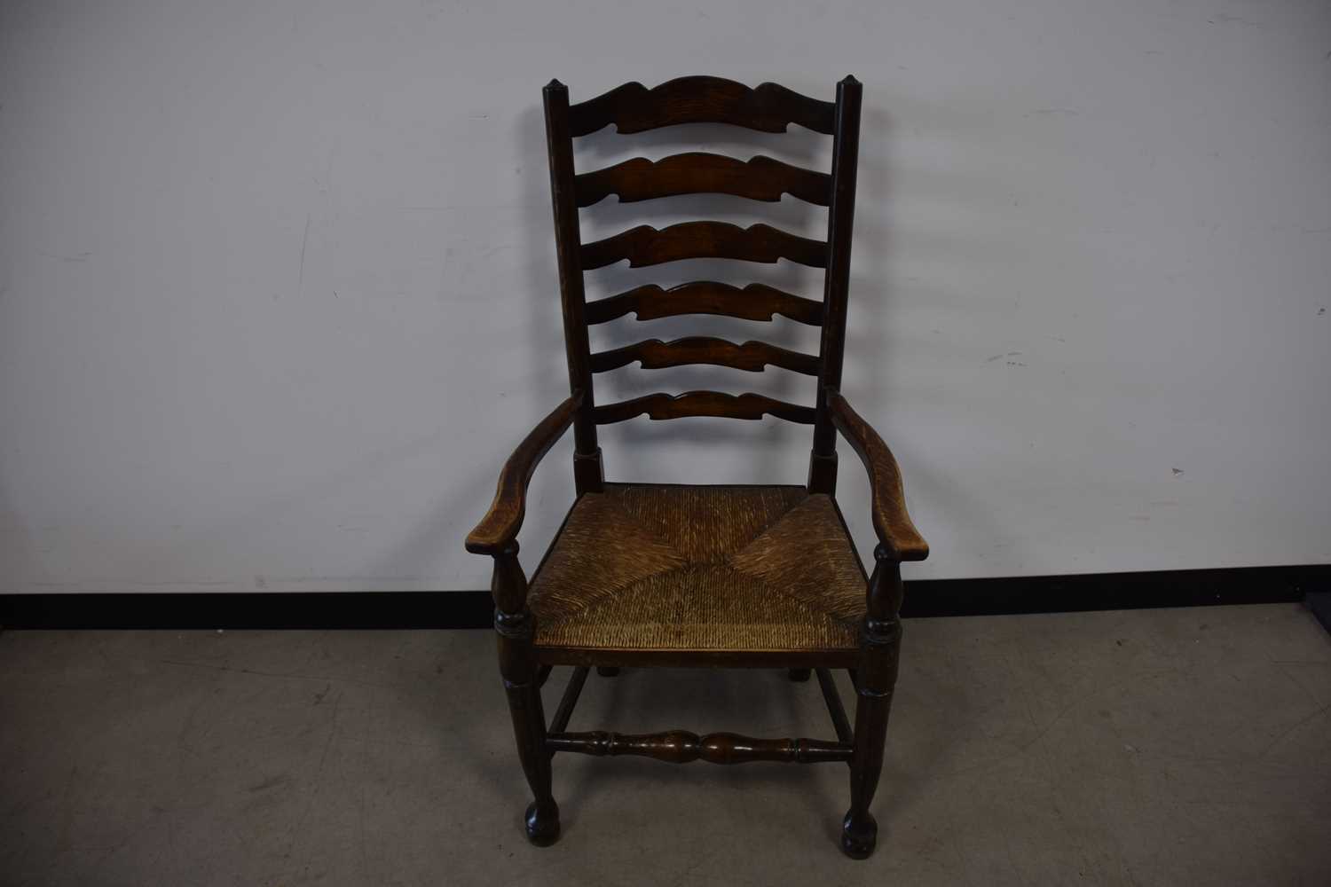 Lot 69 - An antique mixed wood ladder back chair