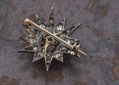 Lot 10 - An Edwardian old cut diamond twelve point star cluster brooch