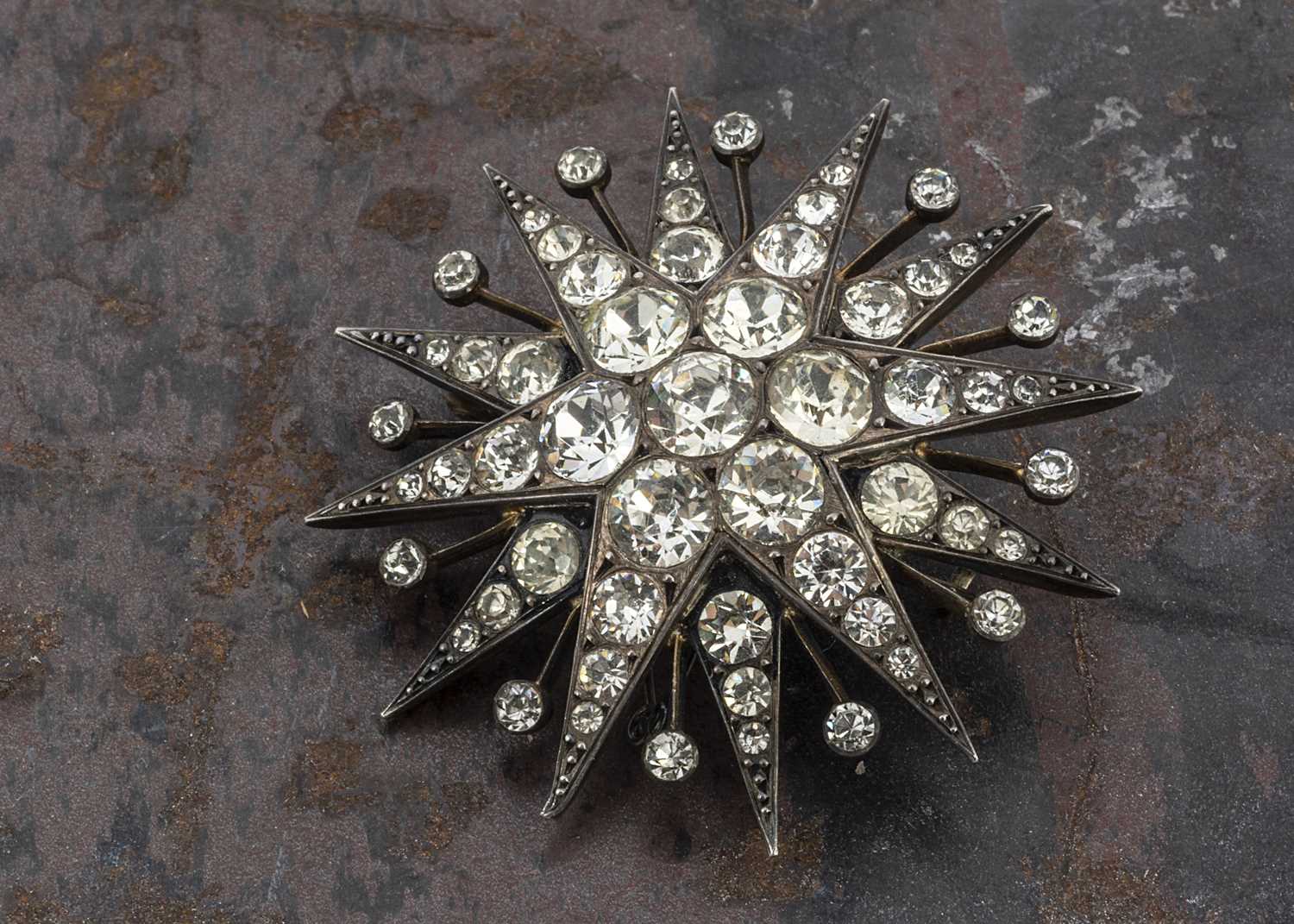 Lot 27 - An early 20th Century silver and paste set twelve point star brooch