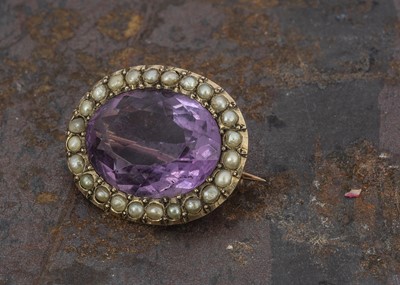 Lot 100 - An Edwardian 9ct gold amethyst and seed pearl oval brooch