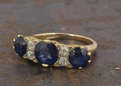 Lot 121 - An early 20th Century three stone sapphire and diamond dress ring