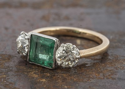 Lot 235 - A three stone emerald and diamond dress ring