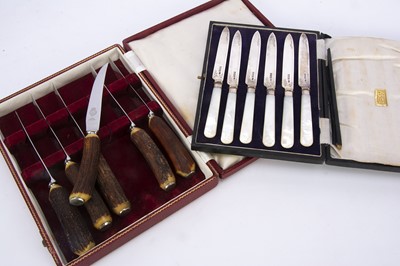 Lot 519 - A set of six cased Victorian silver and mother of pearl handled dessert knives and a set of six antler handled knives in a box