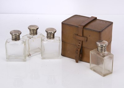 Lot 528 - A set of four George V period travelling bottles with silver lids
