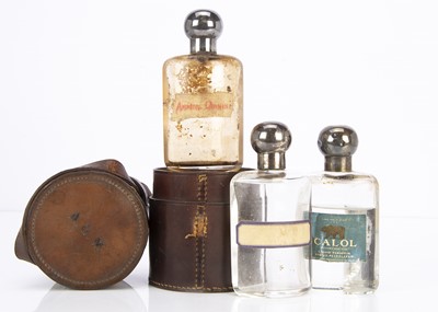 Lot 544 - An early 20th century cased set of three glass and silver capped bottles