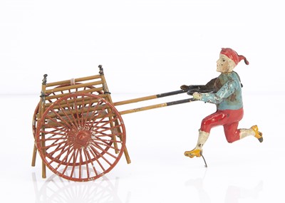 Lot 378 - A German painted tinplate boy pushing a passenger hand-cart