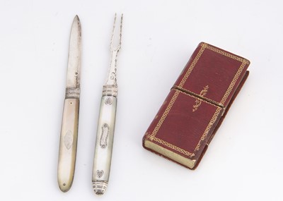 Lot 697 - A early 19th century mother of pearl and silver folding fruit knife and fork in leather book case