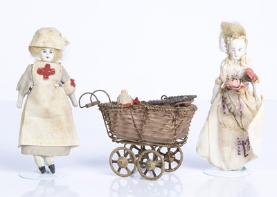 Lot 861 - Two bisque headed dolls’ house dolls and a perambulator