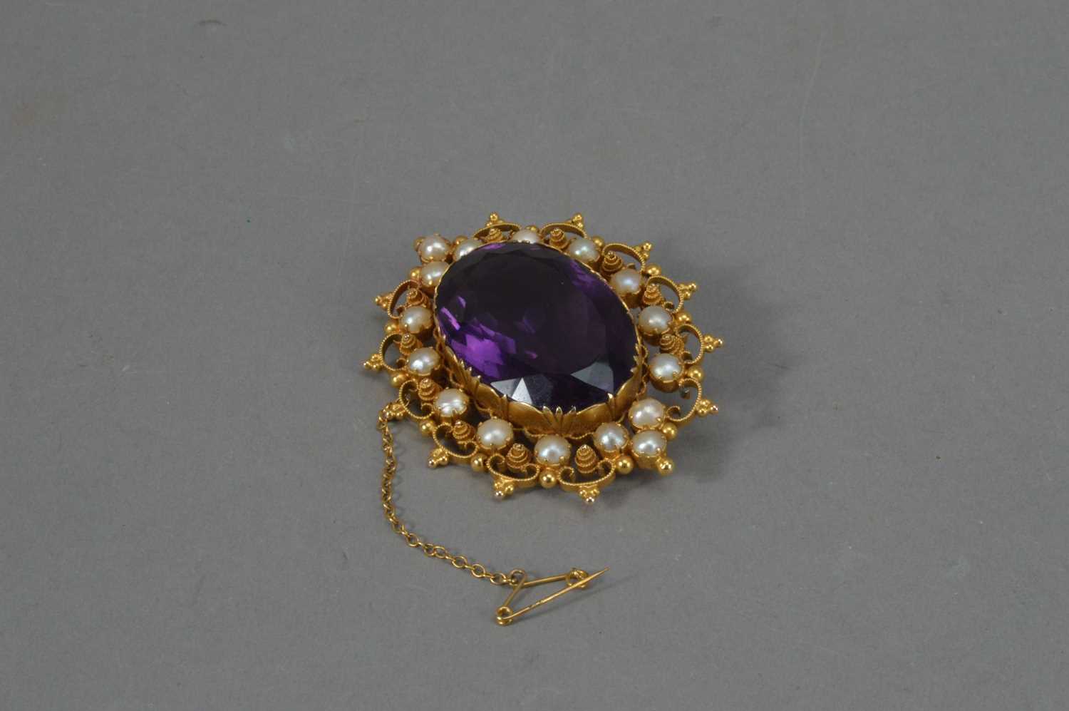 Lot 113 - An Edwardian 9ct marked yellow metal amethyst and seed pearl oval brooch