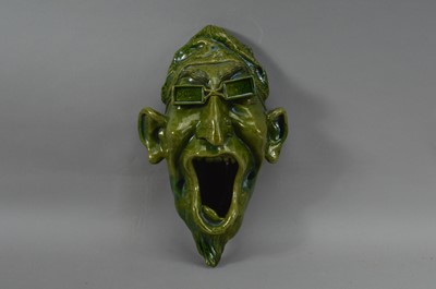 Lot 118 - A Portuguese green ceramic faience wall mounted grotesque head