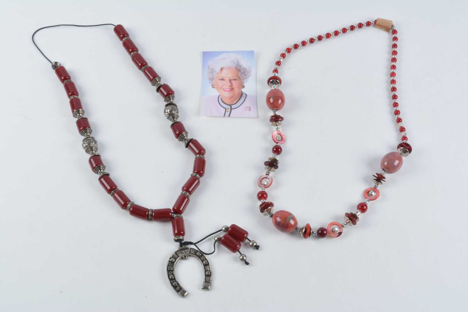 Lot 176 - A string of Middle Eastern simulated cherry amber and white metal beads