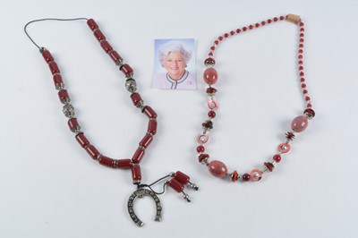 Lot 176 - A string of Middle Eastern simulated cherry amber and white metal beads