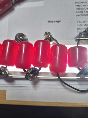 Lot 176 - A string of Middle Eastern simulated cherry amber and white metal beads