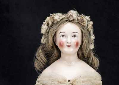 Lot 34 - A rare mid 19th century pink tinted wigged shoulder-head doll