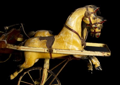 Lot 179 - An early 20th century child’s perambulator with two carved and painted wooden galloping horses