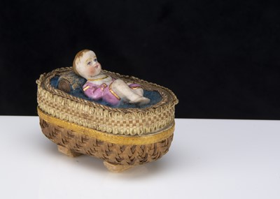 Lot 370 - A 19th century bisque baby lying in a cradle bon-bon box