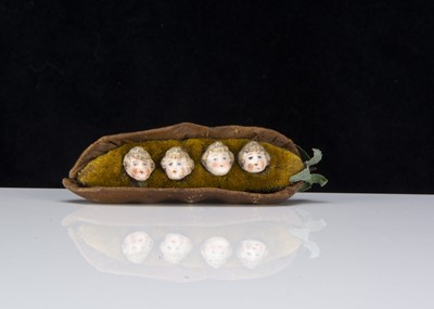 Lot 371 - A late 19th century four bisque heads in a pea-pod pincushion