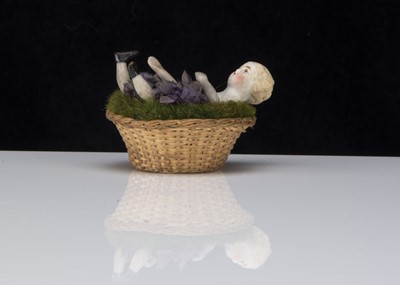 Lot 372 - A 19th century bisque shoulder head doll emerging from a floral basket