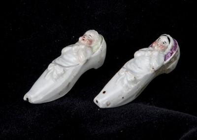 Lot 373 - Two 19th century porcelain whistles in the shape of a baby in a shoe