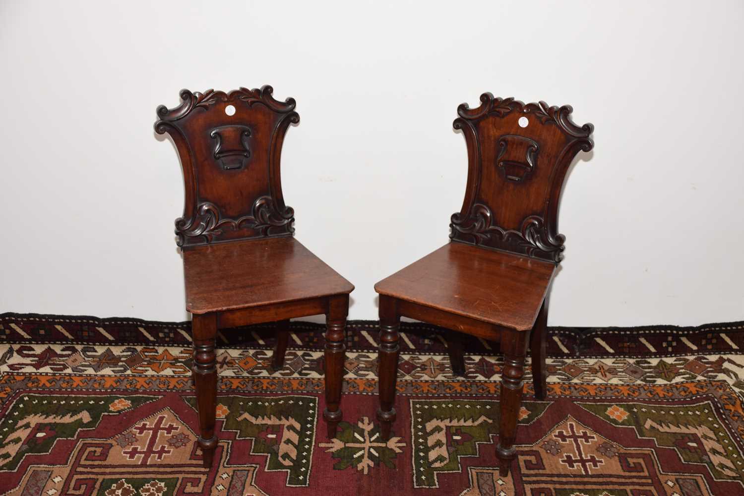 Lot 13 - A pair of Victorian carved mahogany hall chairs