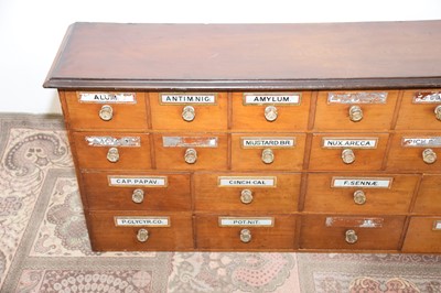 Lot 99 - A Victorian period mahogany apothecary drawer unit, 246cm wide and 64cm high, with multiple drawers, most with glass applied sign and glass knobs, AF