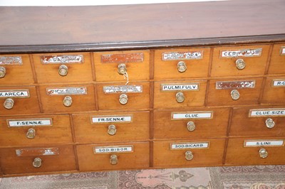 Lot 99 - A Victorian period mahogany apothecary drawer unit, 246cm wide and 64cm high, with multiple drawers, most with glass applied sign and glass knobs, AF