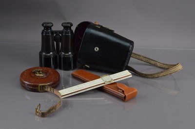 Lot 217 - A pair of binoculars and a surveyor's tape measure and a slide rule