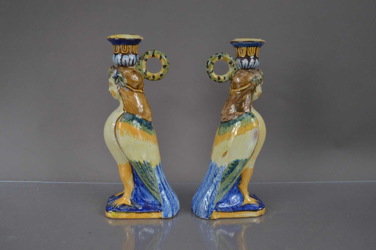 Lot 402 - A pair of faience or majolica neoclassical harpy form candlesticks