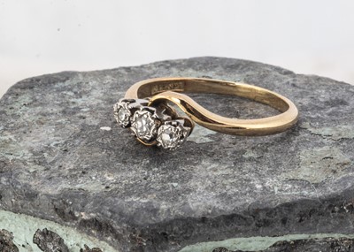 Lot 59 - An 18ct gold and platinum set three stone cross over ring