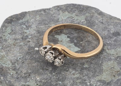 Lot 59 - An 18ct gold and platinum set three stone cross over ring