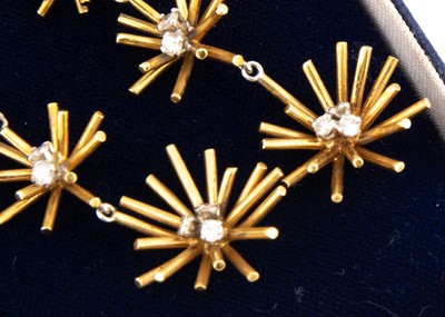 Lot 104 - A pair of 18ct gold and diamond star burst earrings
