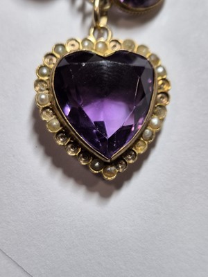 Lot 230 - An Edwardian amethyst and seed pearl heart shaped pendant and chain