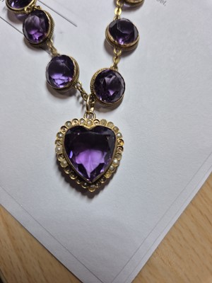 Lot 230 - An Edwardian amethyst and seed pearl heart shaped pendant and chain