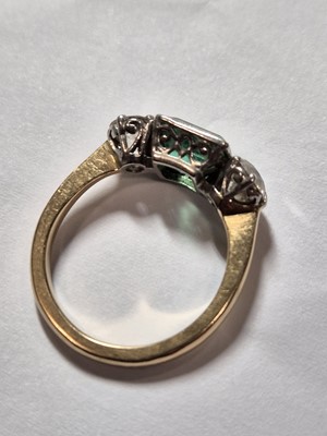 Lot 234 - A three stone emerald and diamond dress ring