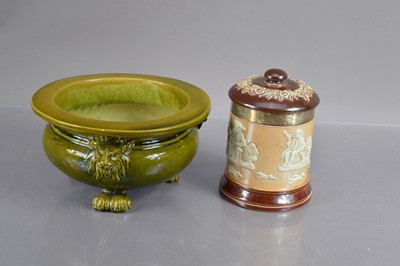 Lot 405 - A Bretby green glazed jardinierre or cache pot with lion masks and lion paw feet