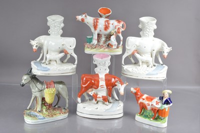 Lot 556 - Five Staffordshire flat back cow form spill vases and a donkey