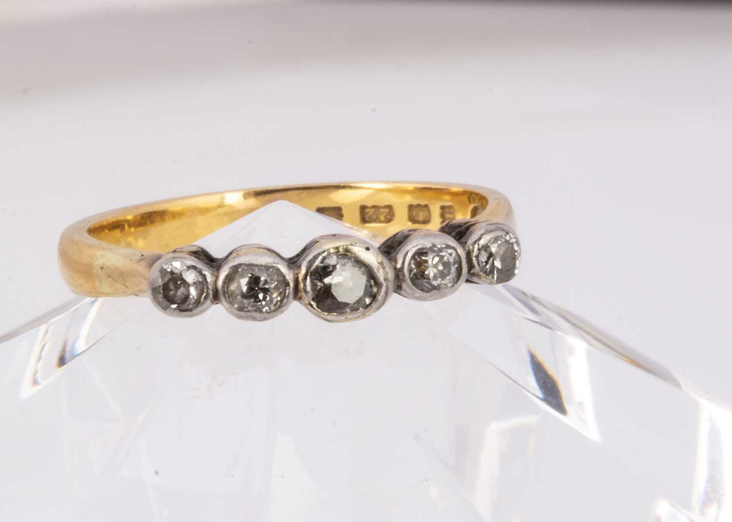 Lot 57 - A 22ct gold wedding band converted to a five stone diamond ring