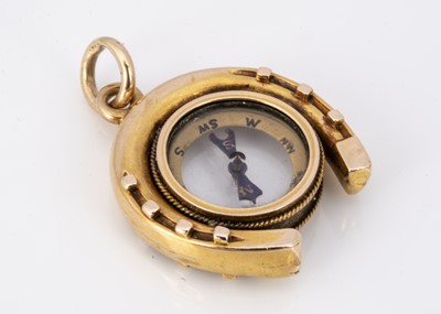 Lot 75 - An Edwardian horseshoe high carat gold compass charm