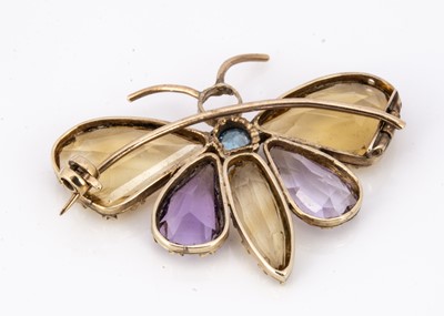 Lot 81 - An Edwardian amethyst, Citrine and aqua gem set gold butterfly brooch